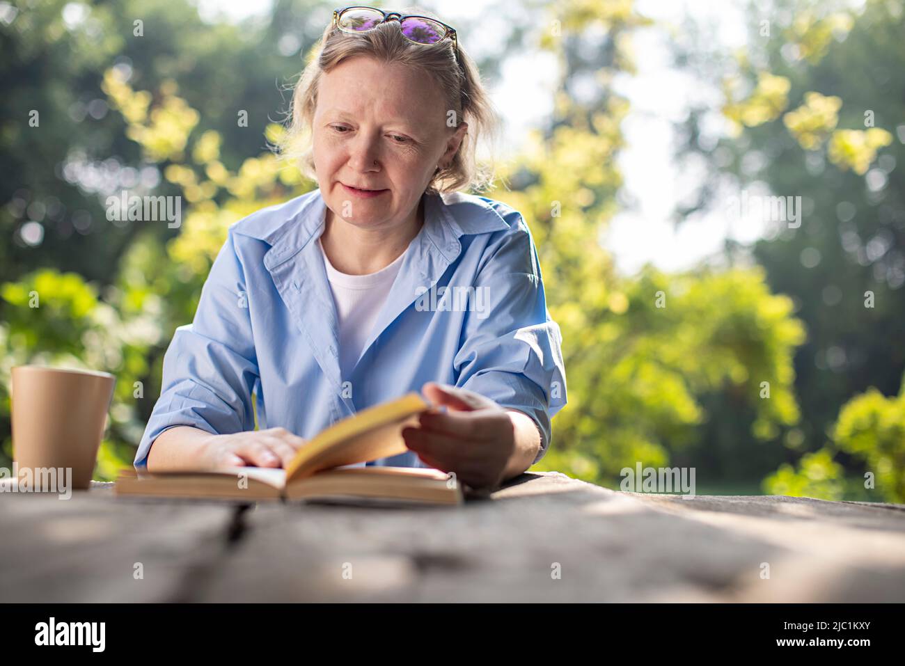 Mature adult woman reading a book in the morning  Stock Photo
