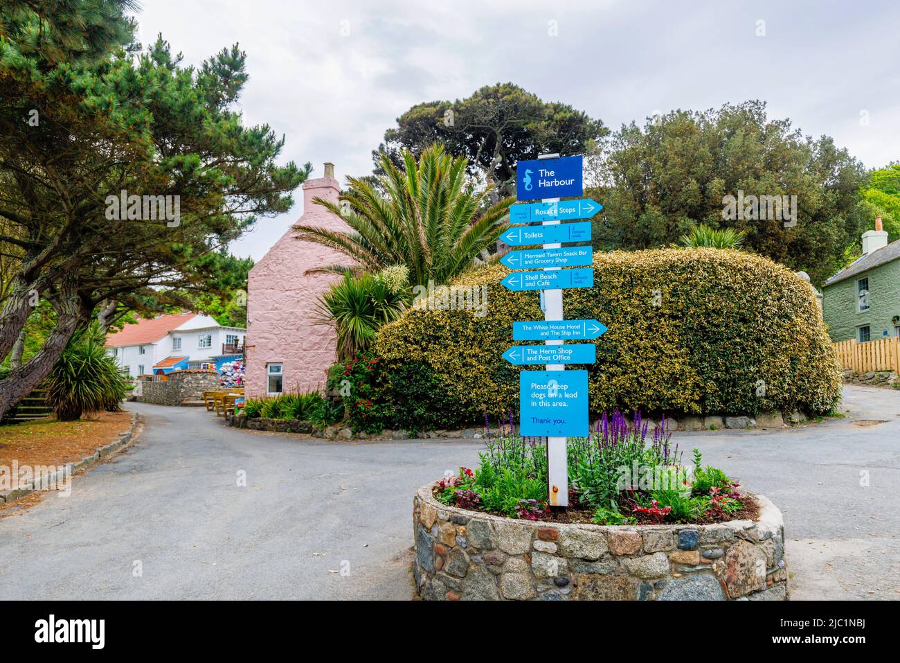 Blue finger post signpost in the Harbour with directions to the attractions of Herm, an Island in the Bailiwick of Guernsey, Channel Islands, UK Stock Photo