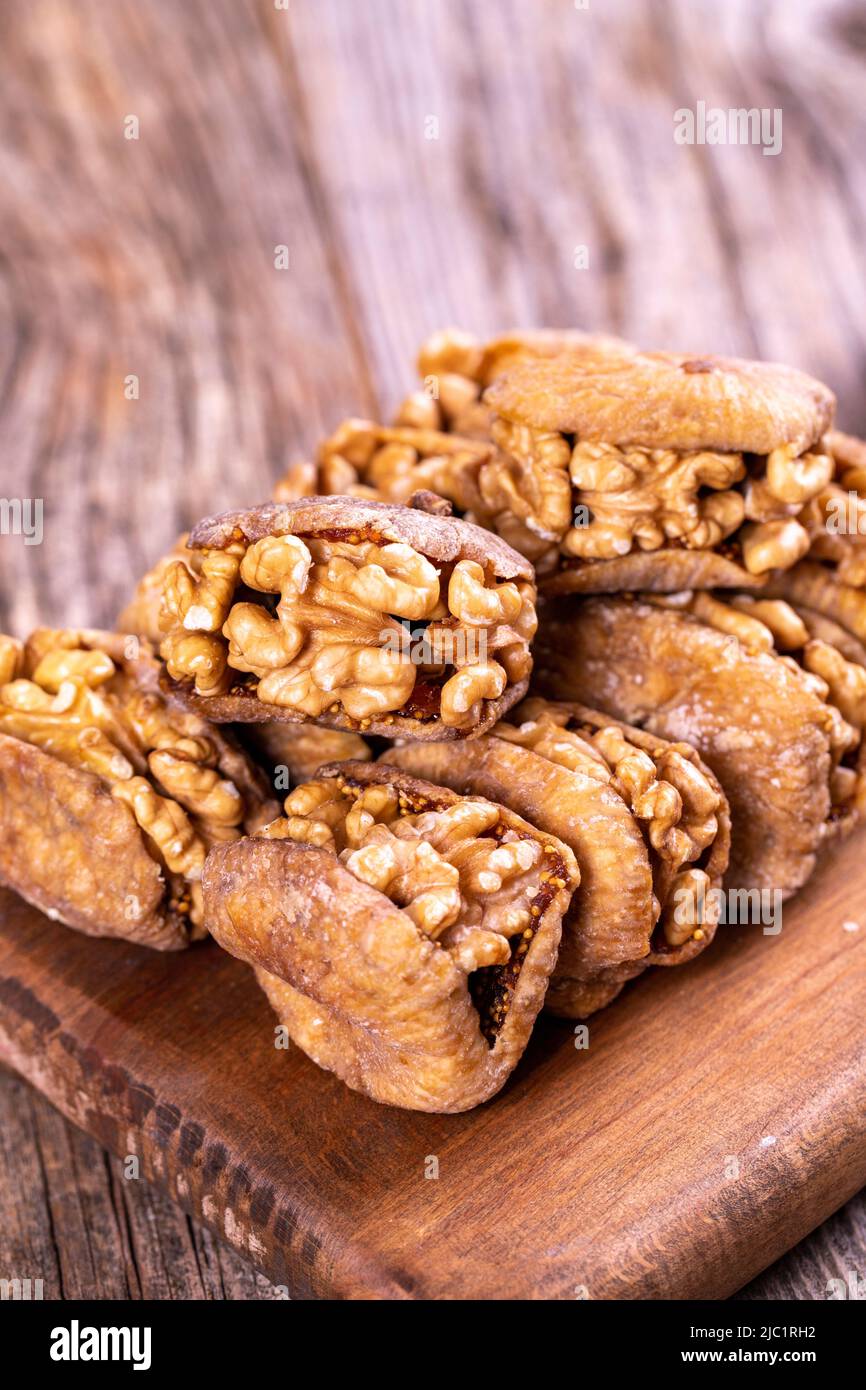 Stuffed dried figs. Dried figs stuffed with walnuts on a wood floor
