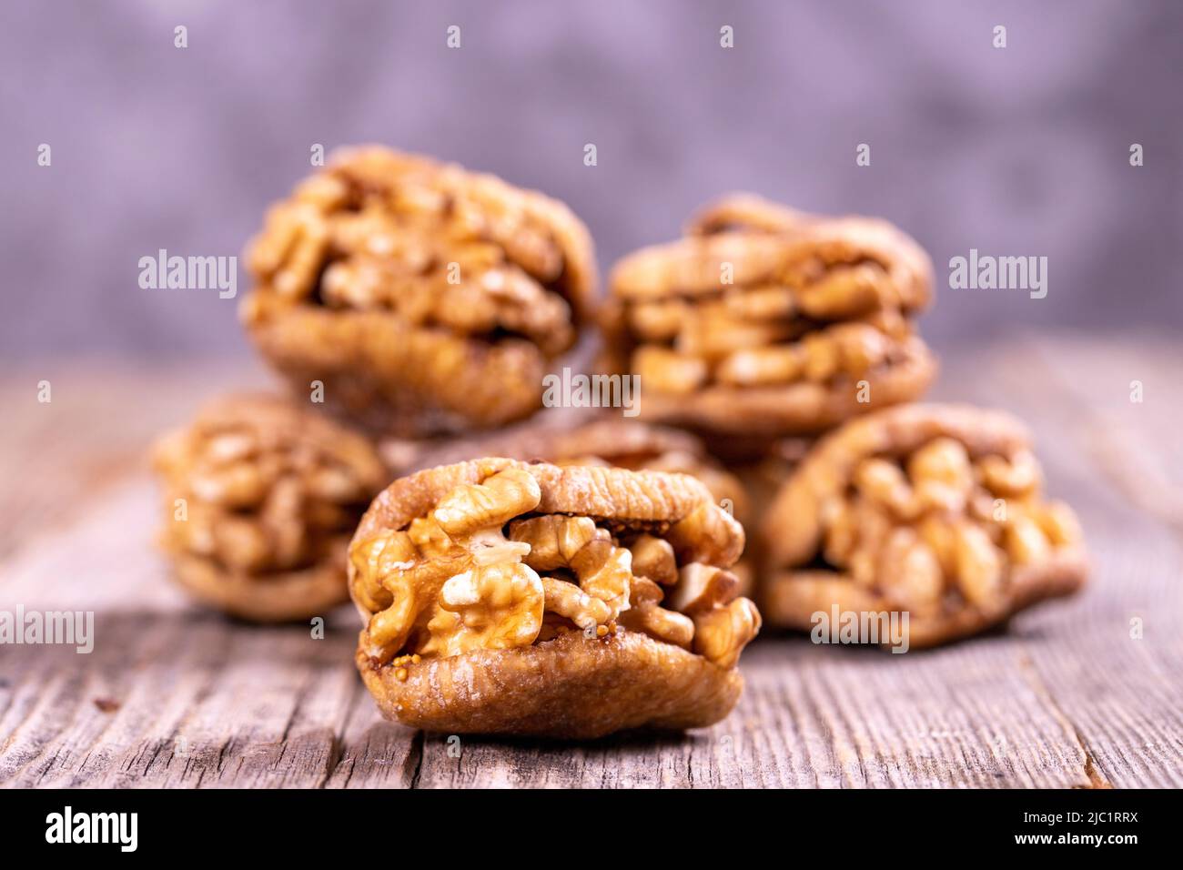 Stuffed dried figs. Dried figs stuffed with walnuts on a wood floor