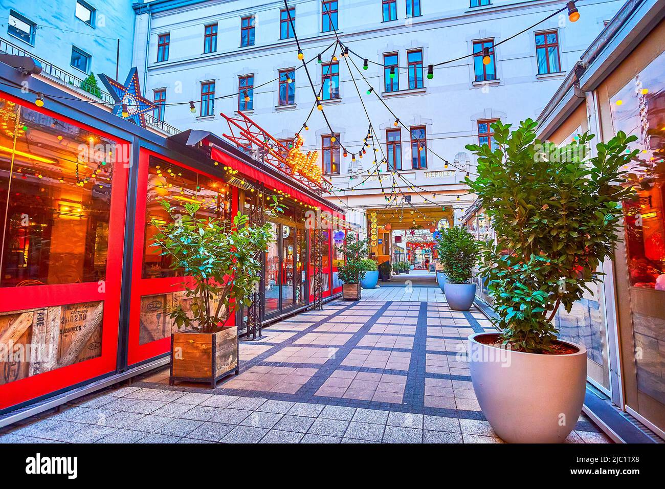 BUDAPEST, HUNGARY - FEBRUARY 23, 2022: The bright windows of night clubs and restaurants of Gozsdu Courtyard, the famous modern entertainment quarter, Stock Photo