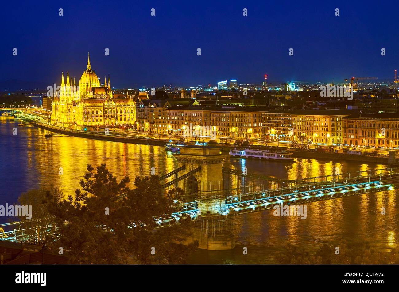 The bright night illumination of Parliament and other buildings on Pest side of Budapest, Hungary Stock Photo