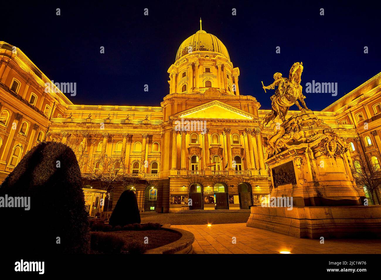 BUDAPEST, HUNGARY - FEBRUARY 23, 2022: The night view on illuminated front facade of Buda Castle with Prince Eugene of Savoy monument, on February 23 Stock Photo