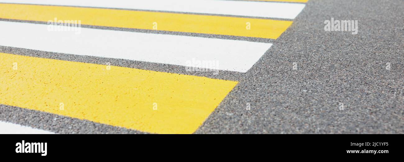 Marked white and yellow walkway across road or street Stock Photo