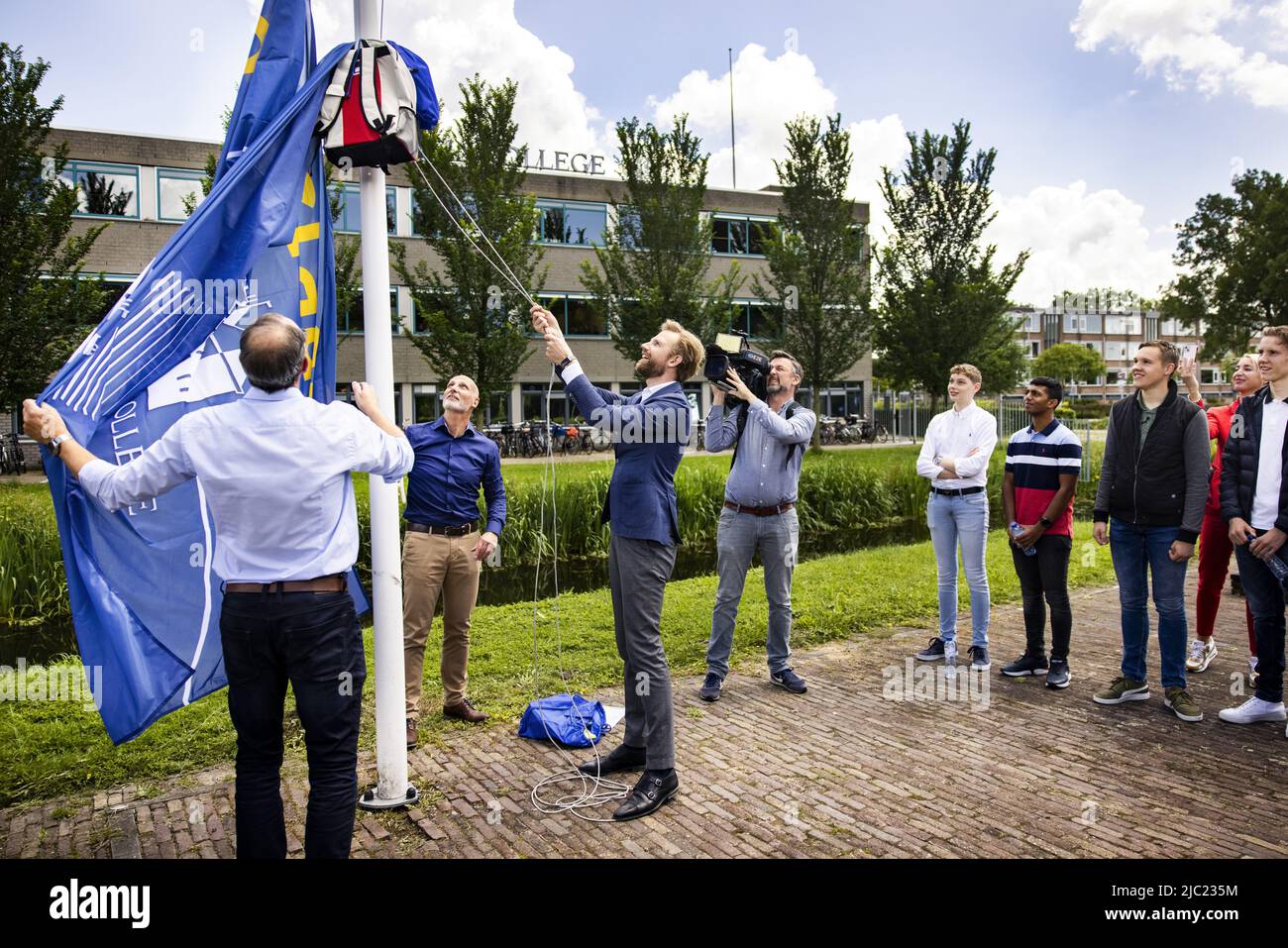 2022-06-09 14:32:08 ZWIJNDRECHT - Minister Dennis Wiersma for Primary and  Secondary Education raises the flags for the successful students of  Develstein College. Thousands of students from VMBO (theoretical and mixed  learning path),