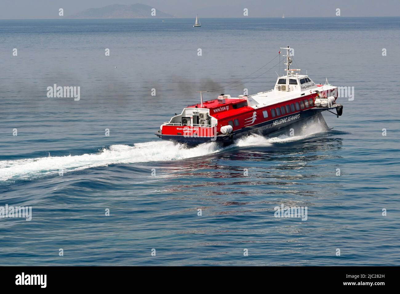 Aegina, Greece, - May 2022: Fast hydrofoil ferry accelerating with thick black smoke emerging from its funnels. Stock Photo