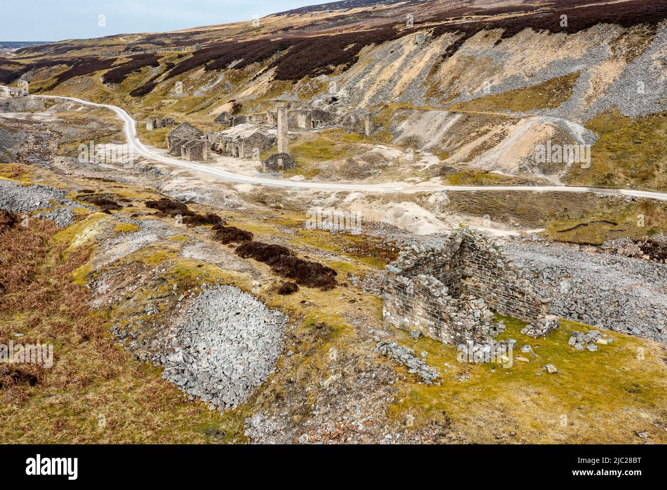 ruins of the old gang lead mine in the hills above reeth in the yorkshire dales from the hillside opposite horizontal format Stock Photo
