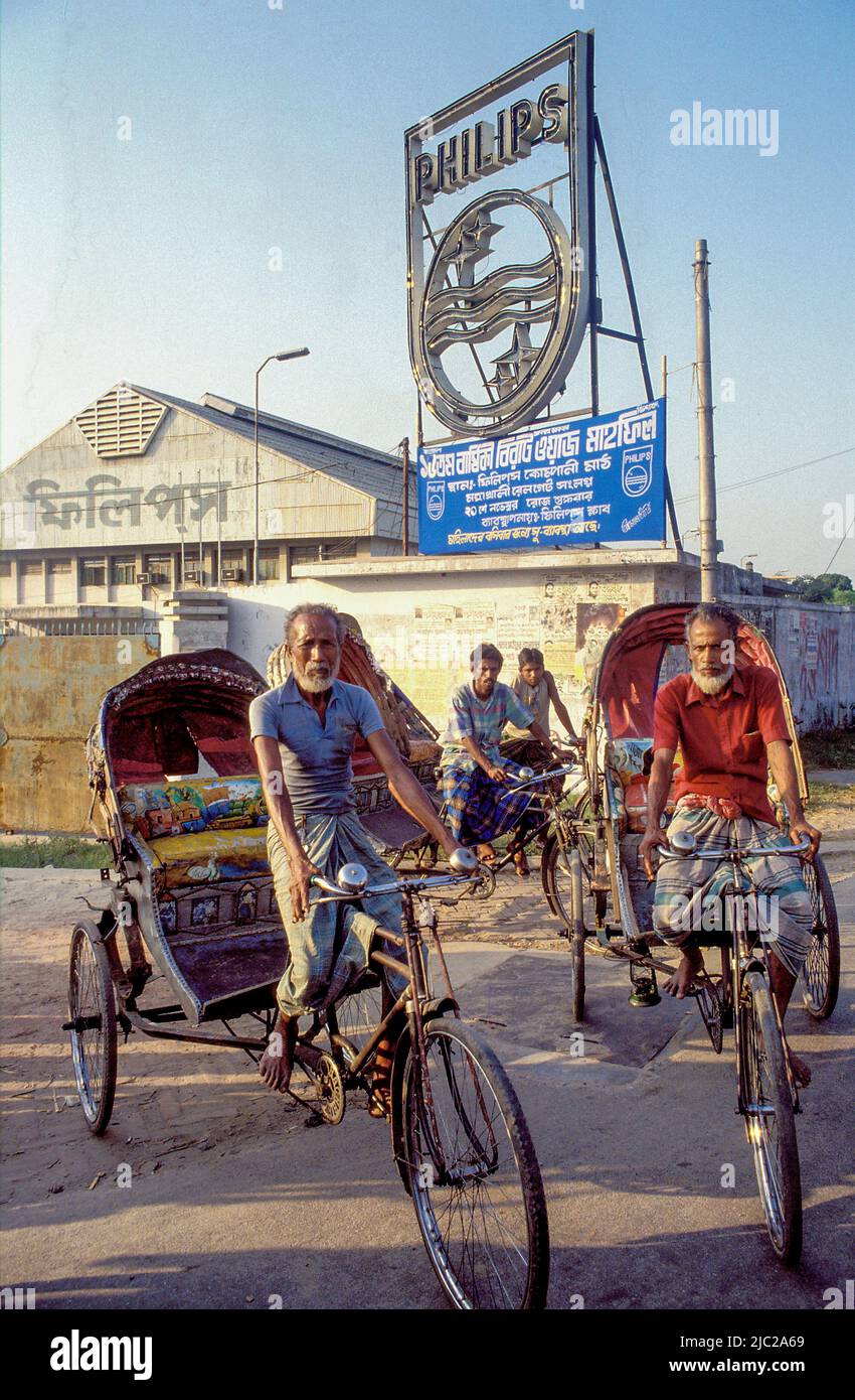 Bangladesh; men on trishaws in front of the philips logo. Stock Photo