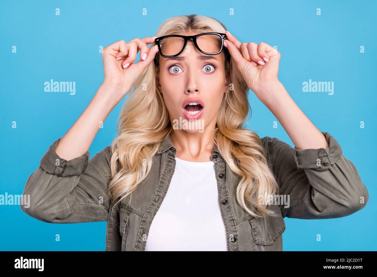 Photo portrait smiling woman wearing glasses grey shirt staring amazed