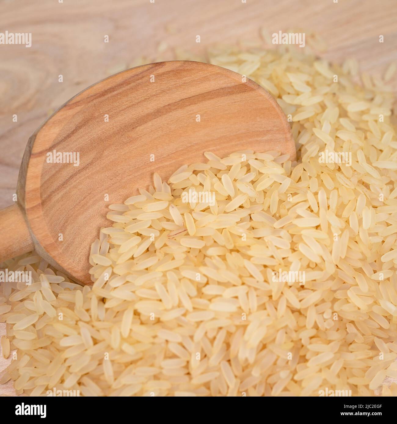 Rice grains and wooden spoon in a close-up Stock Photo - Alamy