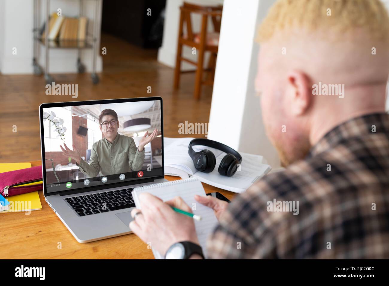 Asian businessman gesturing on video call during meeting with albino african male colleague Stock Photo