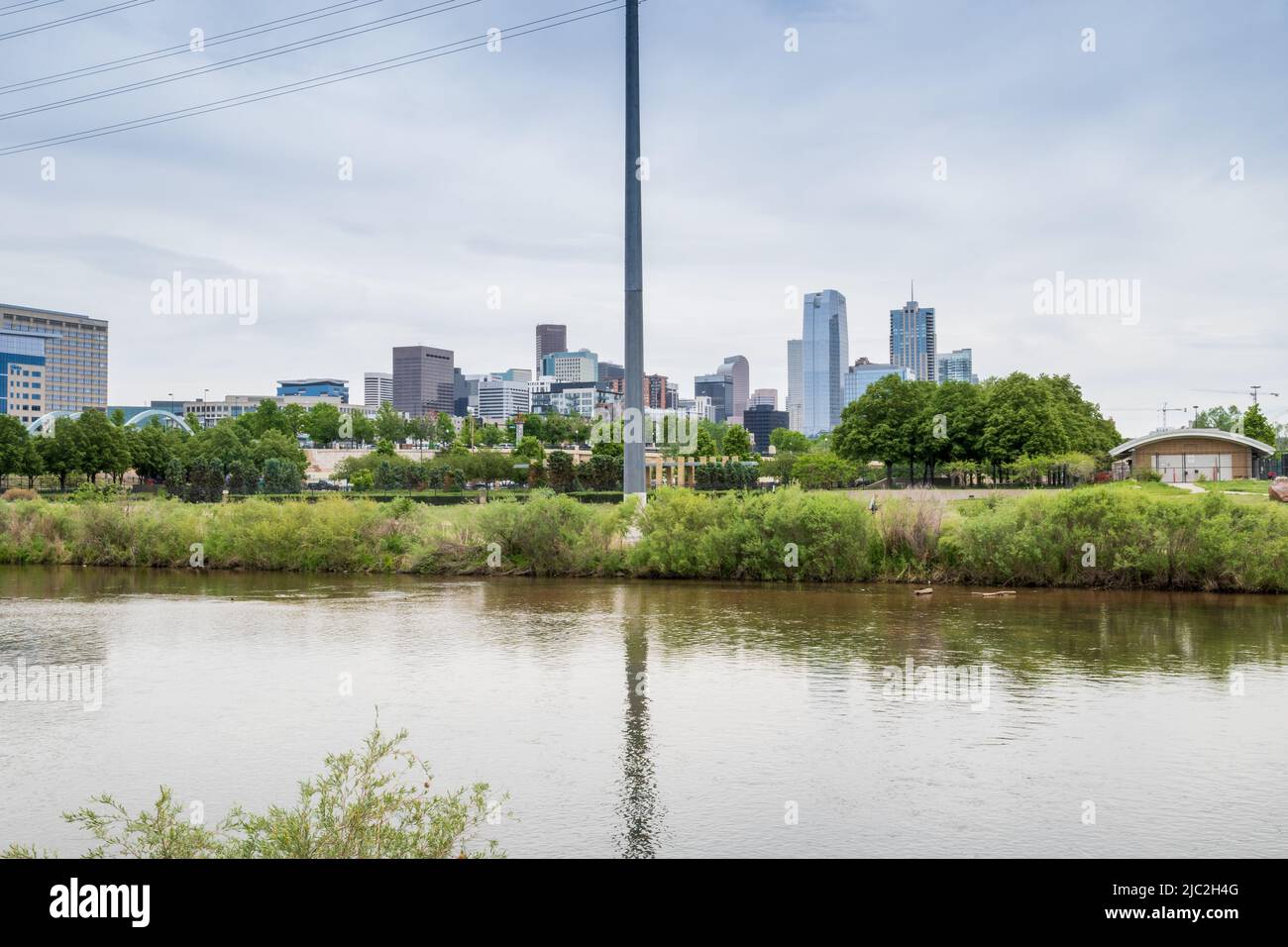 Denver, Colorado, May 28, 2022. Denver downtown skyline viewed from the South Platter River trail near the Aquarium, divided up by a power line pole Stock Photo