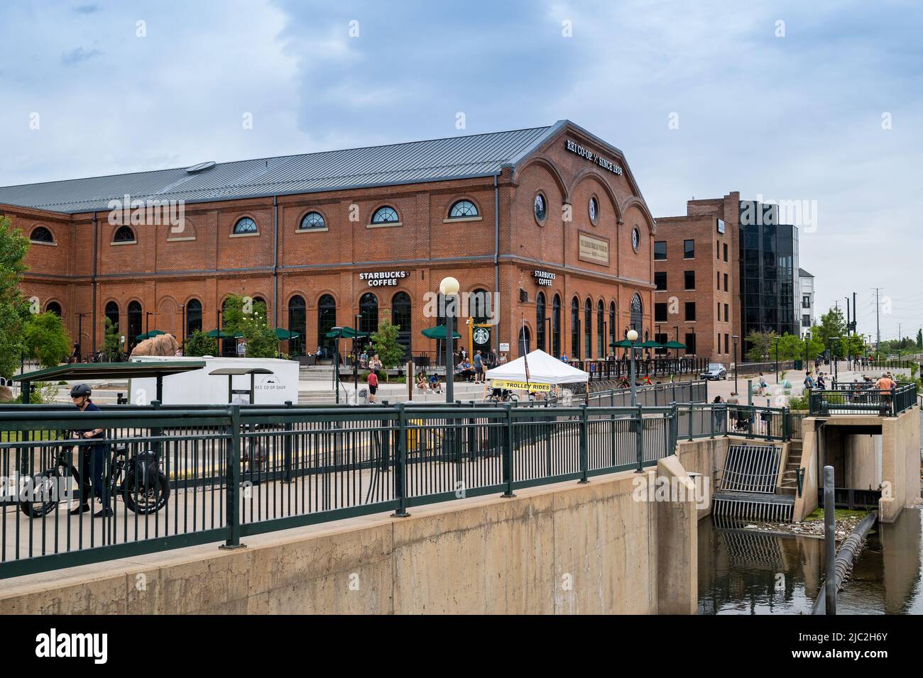 Denver, Colorado, May 28, 2022. Side View of the REI historical building, the public walking and biking on the South Platter River Trail Stock Photo