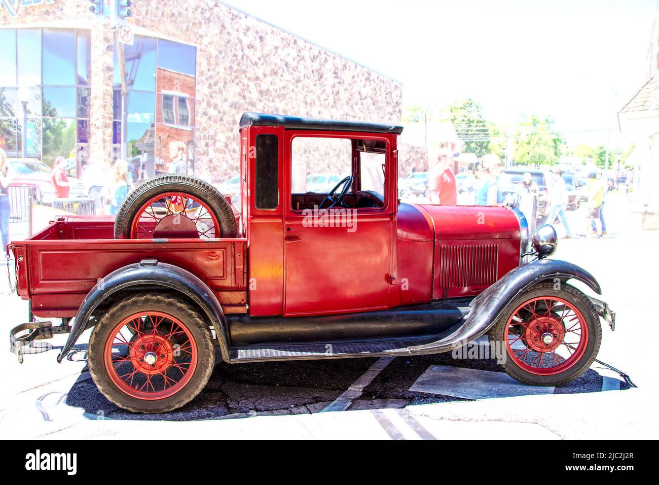 4-30-2022 Tahlequah OK USA - Vintage  red antique truck with wire wheels parked in street at small town event copy space Stock Photo