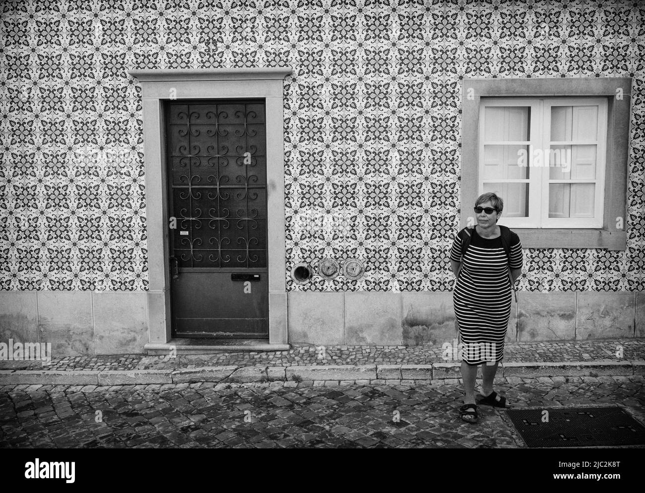 Traditional tiled house and woman in striped dress, Tavira, Algarve, Portugal Stock Photo