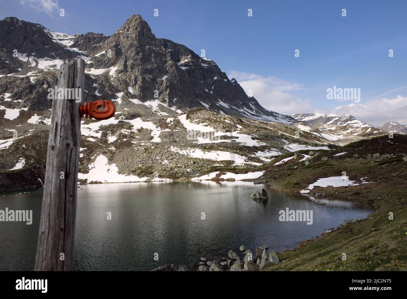 Silvaplana, Julierpass, Switzerland, Small lake in Alp mountains. Julierpass by Spring landscape with snow on top of mountain and green grass. Stock Photo
