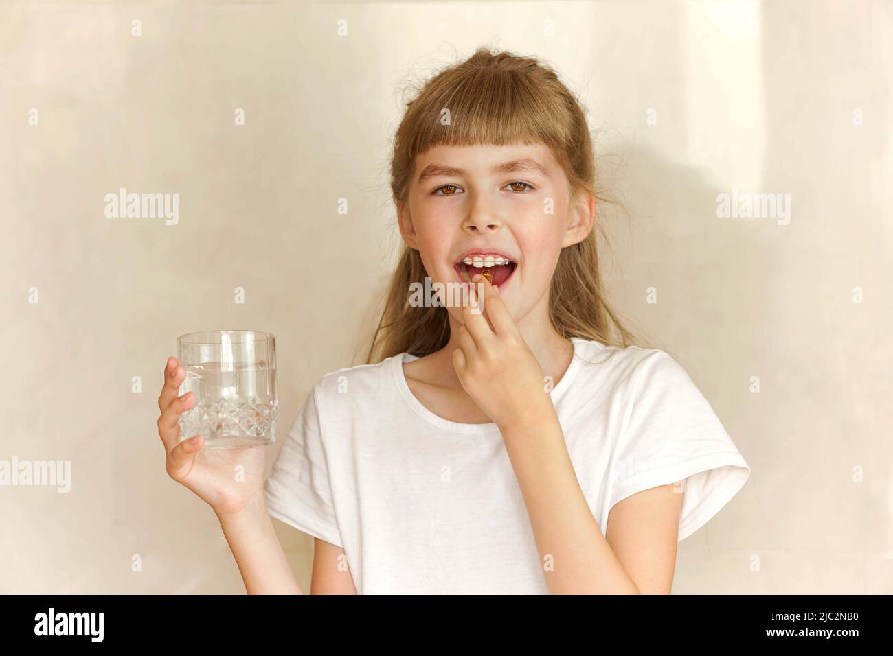Little girl drinks omega 3 water and smiles. Stock Photo