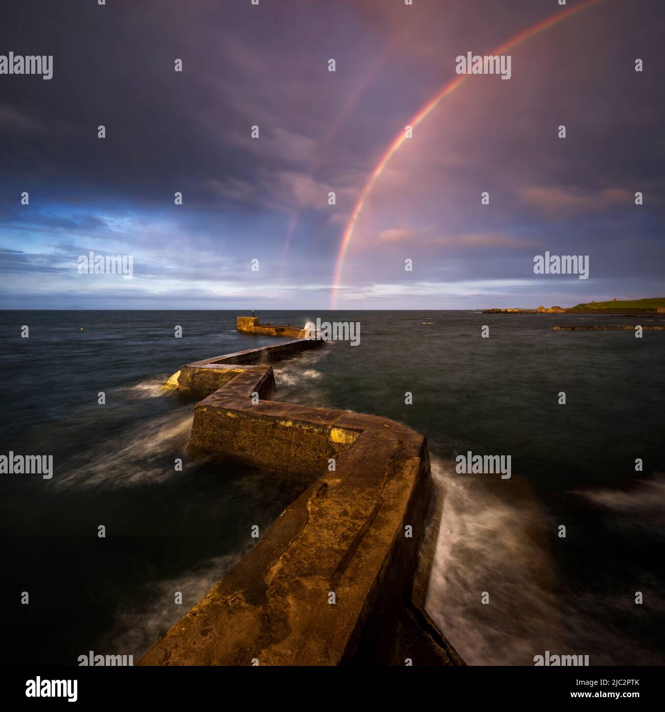 Rainbow over zig zag pier in St. Monans village, east coast of Scotland Stock Photo