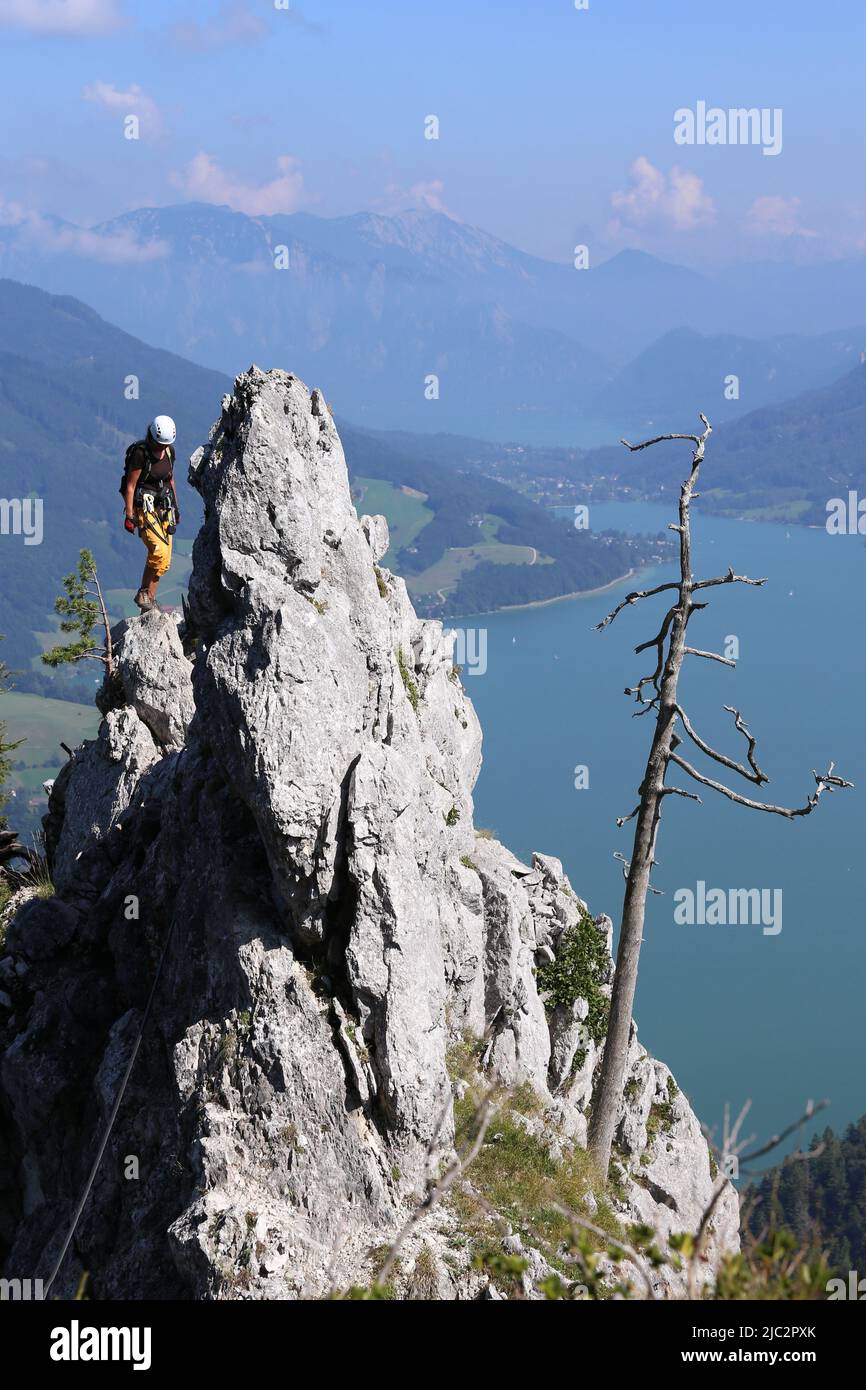Woman climbs high over the Mondsee in Austria Stock Photo