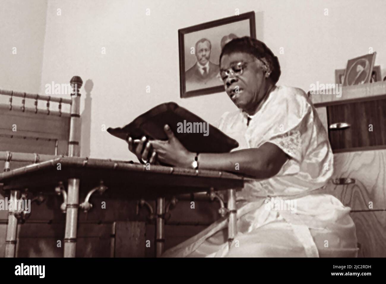 Dr. Mary McLeod Bethune (1875-1955) reading from the Bible, as she did each night before retiring for the evening, in January, 1943, in Daytona Beach, Florida, at Bethune-Cookman College, of which she was a founder. (USA) Stock Photo