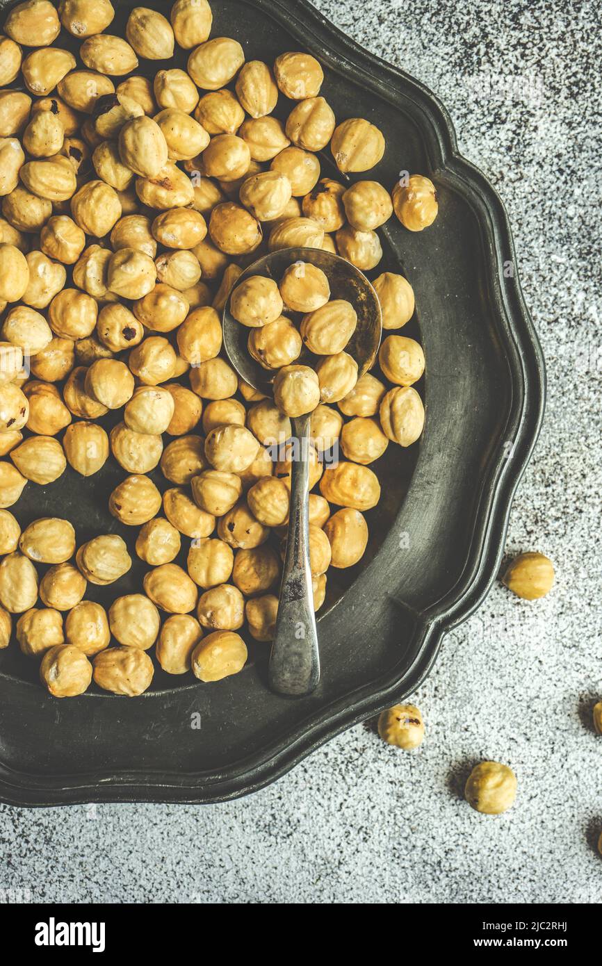 Overhead view of hazelnuts on a pewter plate Stock Photo