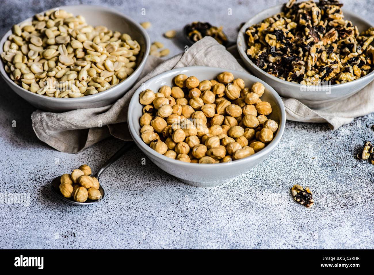 Close-Up of three bowls of hazelnuts, walnuts and peanuts Stock Photo