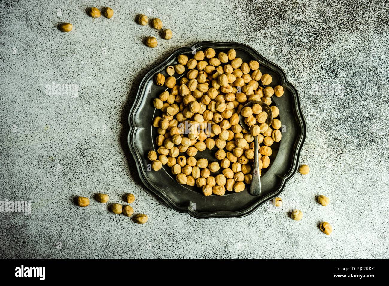 Overhead view of hazelnuts on a pewter plate Stock Photo