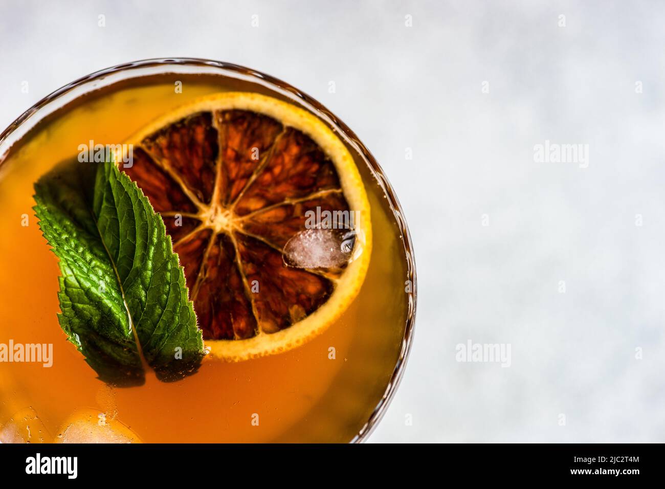 Overhead view of a cocktail with a slice of orange and fresh mint Stock Photo