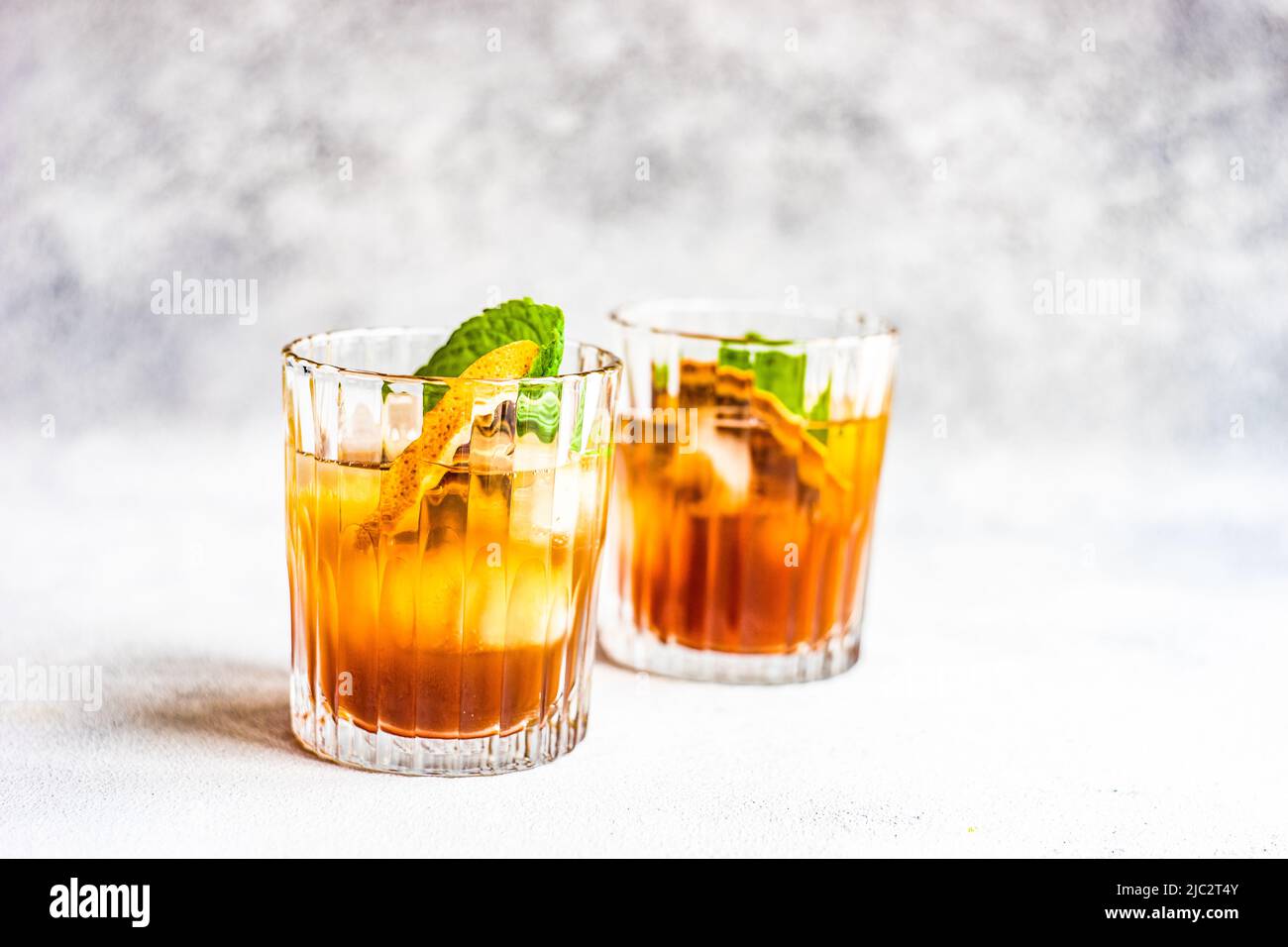 Two cocktails in a glass with a slice of orange and fresh mint Stock Photo