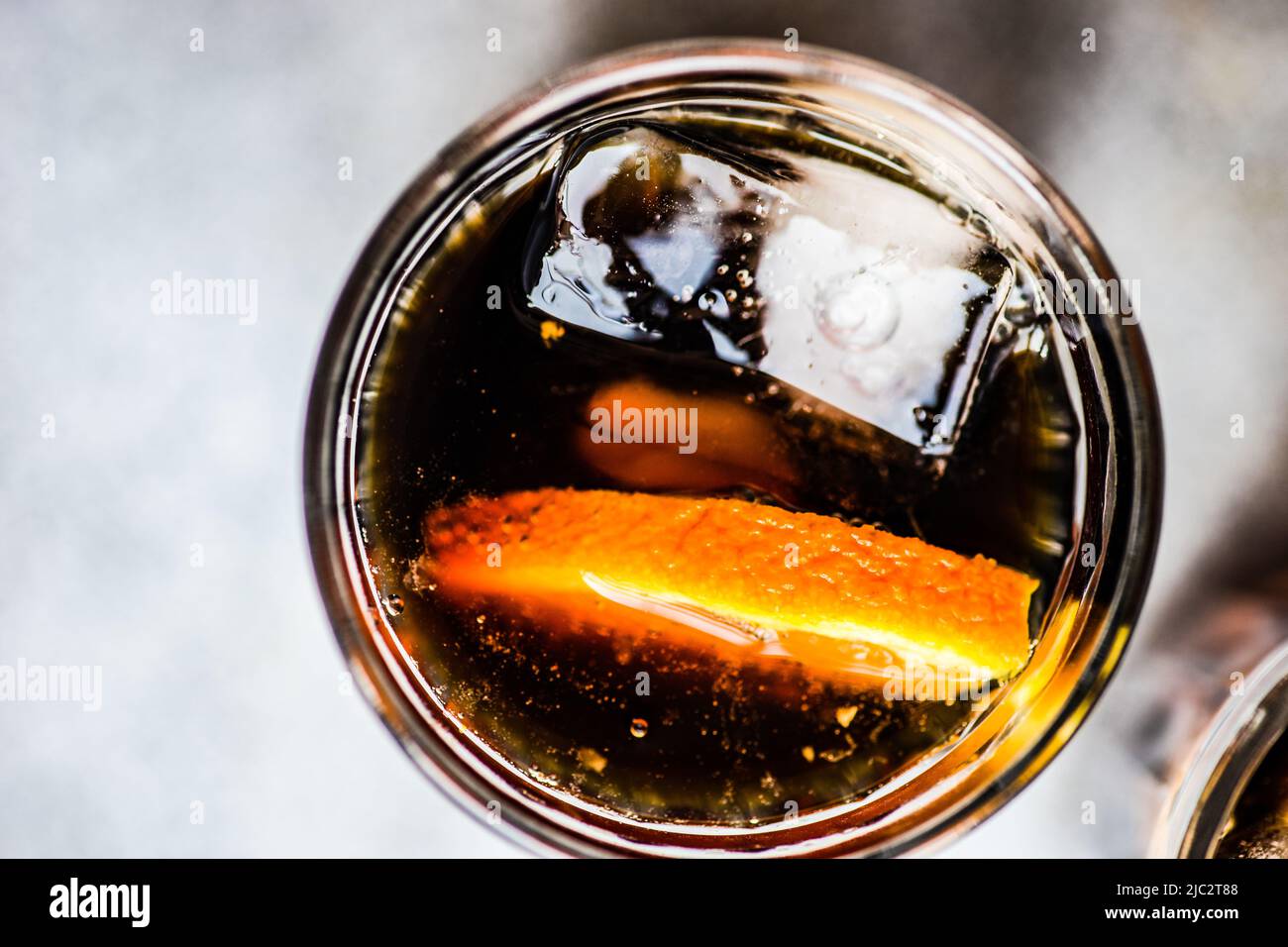 Overhead view of a cola drink with ice cubes and a slice of fresh orange Stock Photo