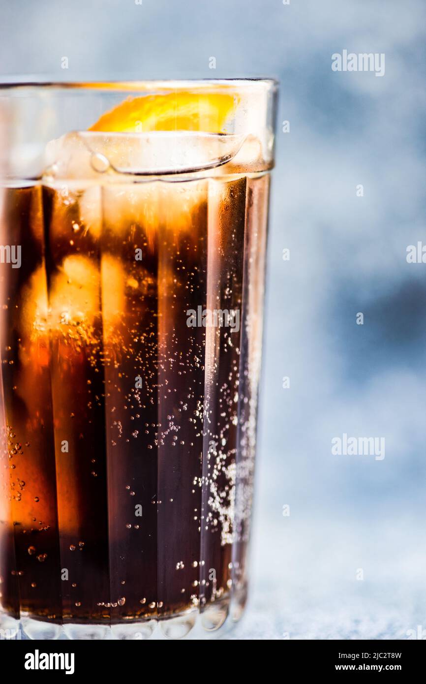 Close-up of a cola drink with ice cubes and a slice of fresh orange Stock Photo