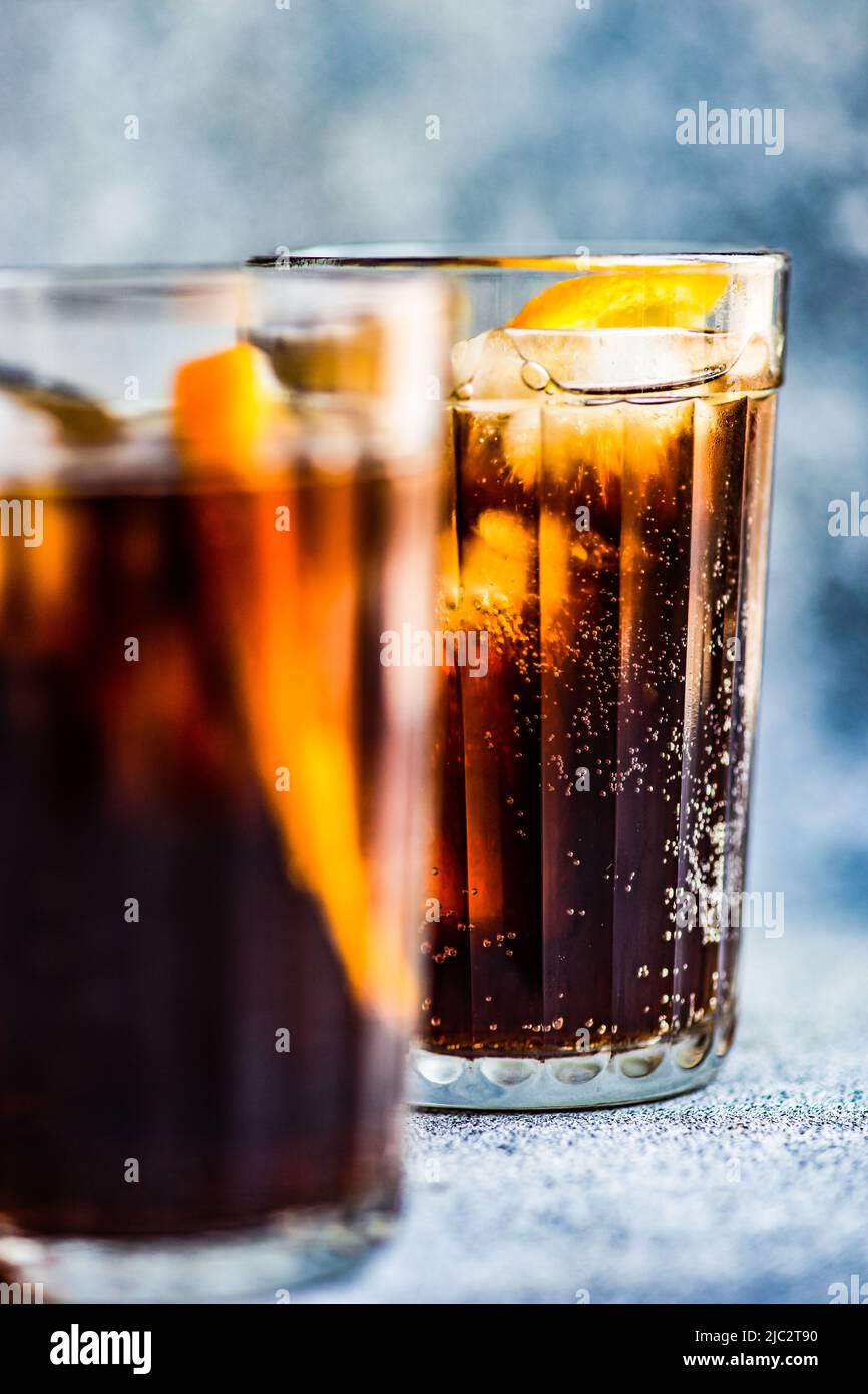 Close-up of two cola drinks with ice cubes and slices of fresh orange Stock Photo