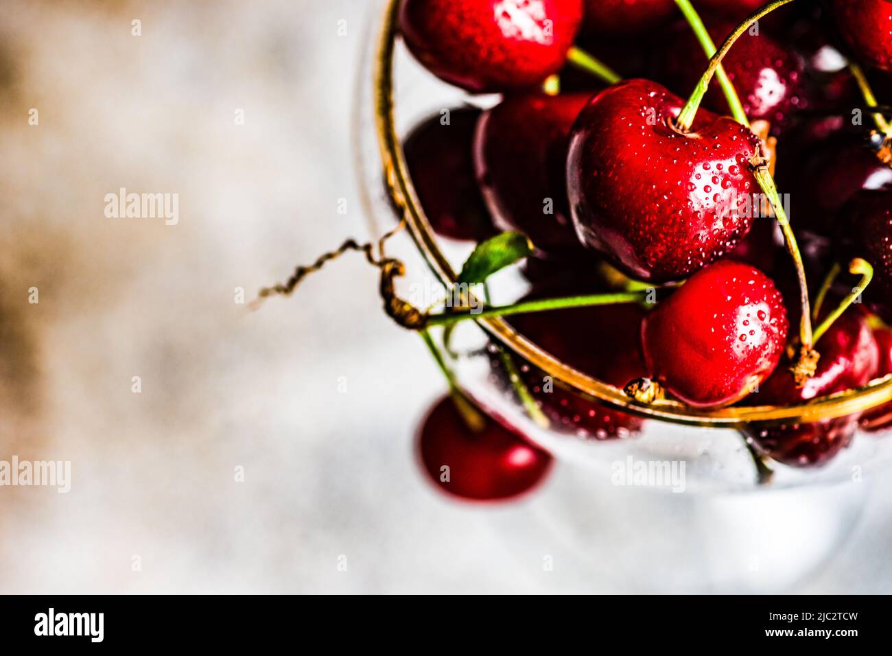 Overhead view of cherries in a gold rim champagne coupe Stock Photo