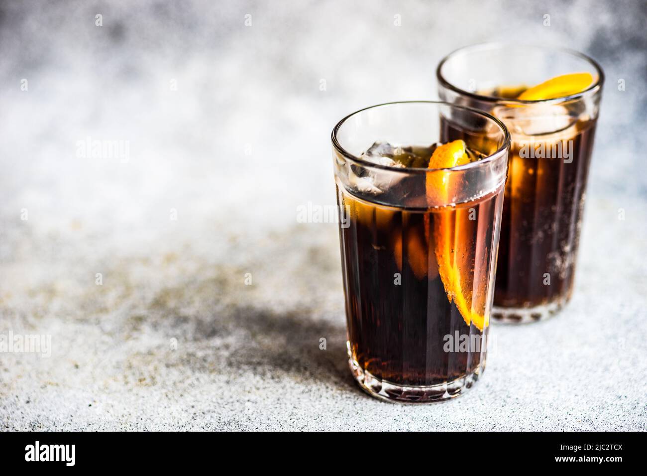 Close-up of two cola drinks with ice cubes and slices of fresh orange Stock Photo