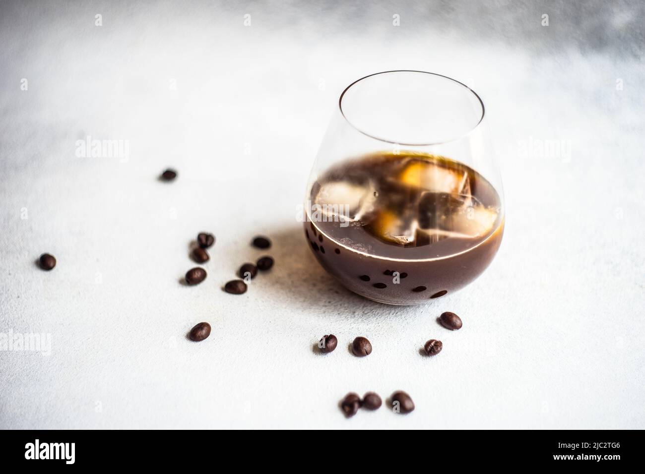 Close-up of an iced coffee drink on a table with roasted coffee beans Stock Photo