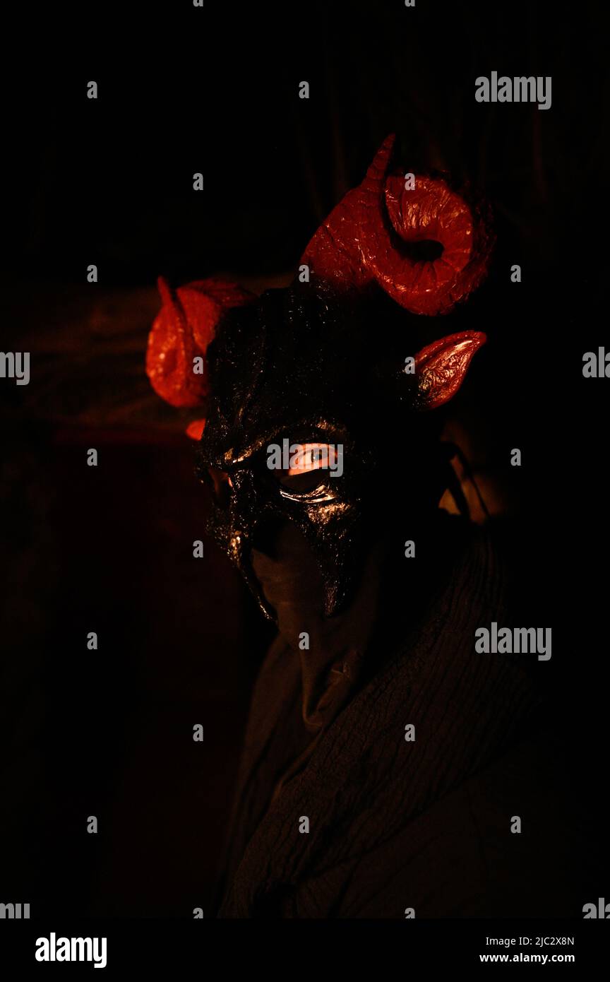 Sinister masked figure with devil mask in the woods Stock Photo