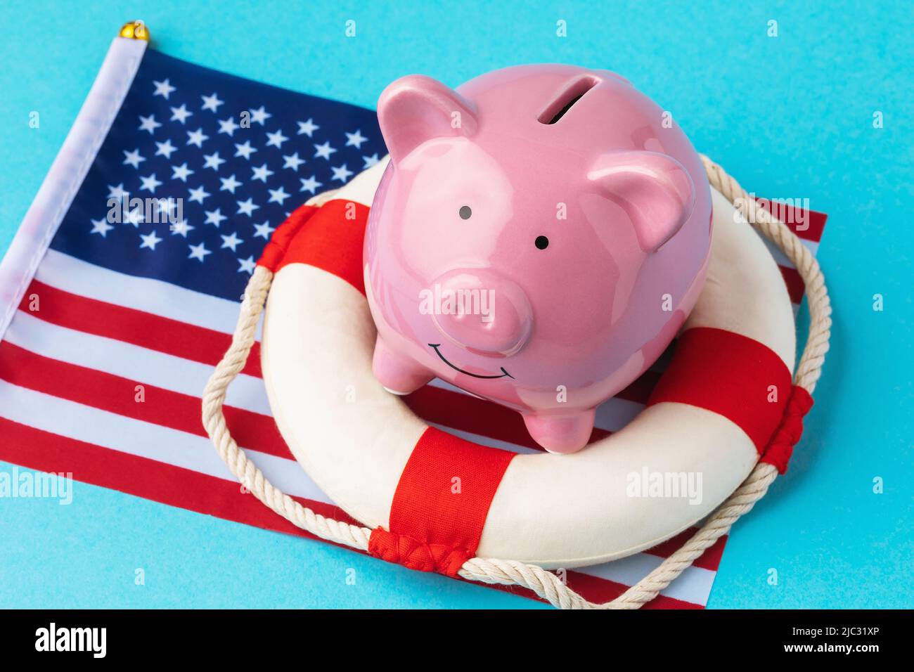 Piggy bank, lifebuoy and flag on a blue background, the concept of saving the American economy Stock Photo