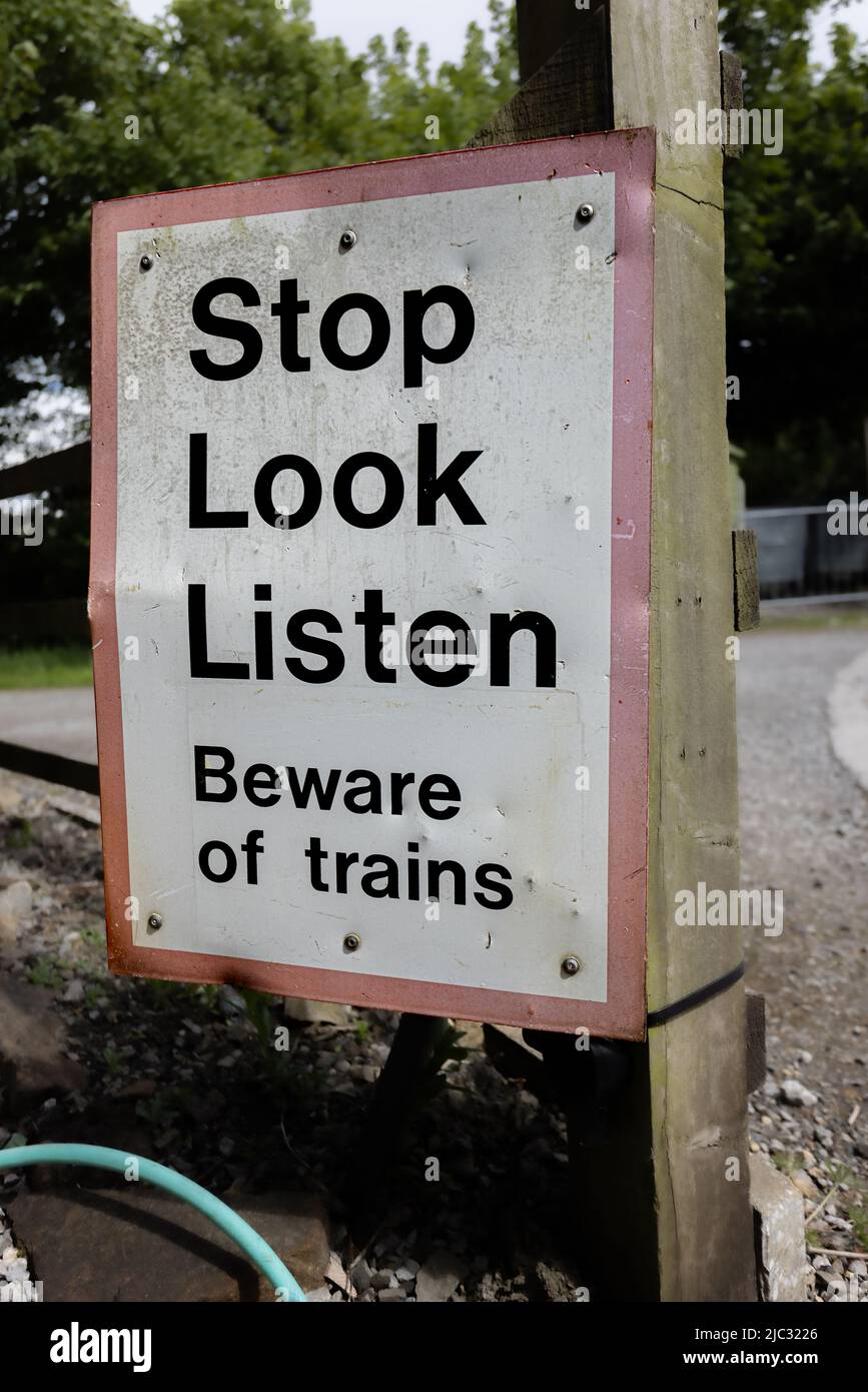 Stop look listen, beware of trains sign at Bolton Abbey railway station, Yorkshire, UK Stock Photo