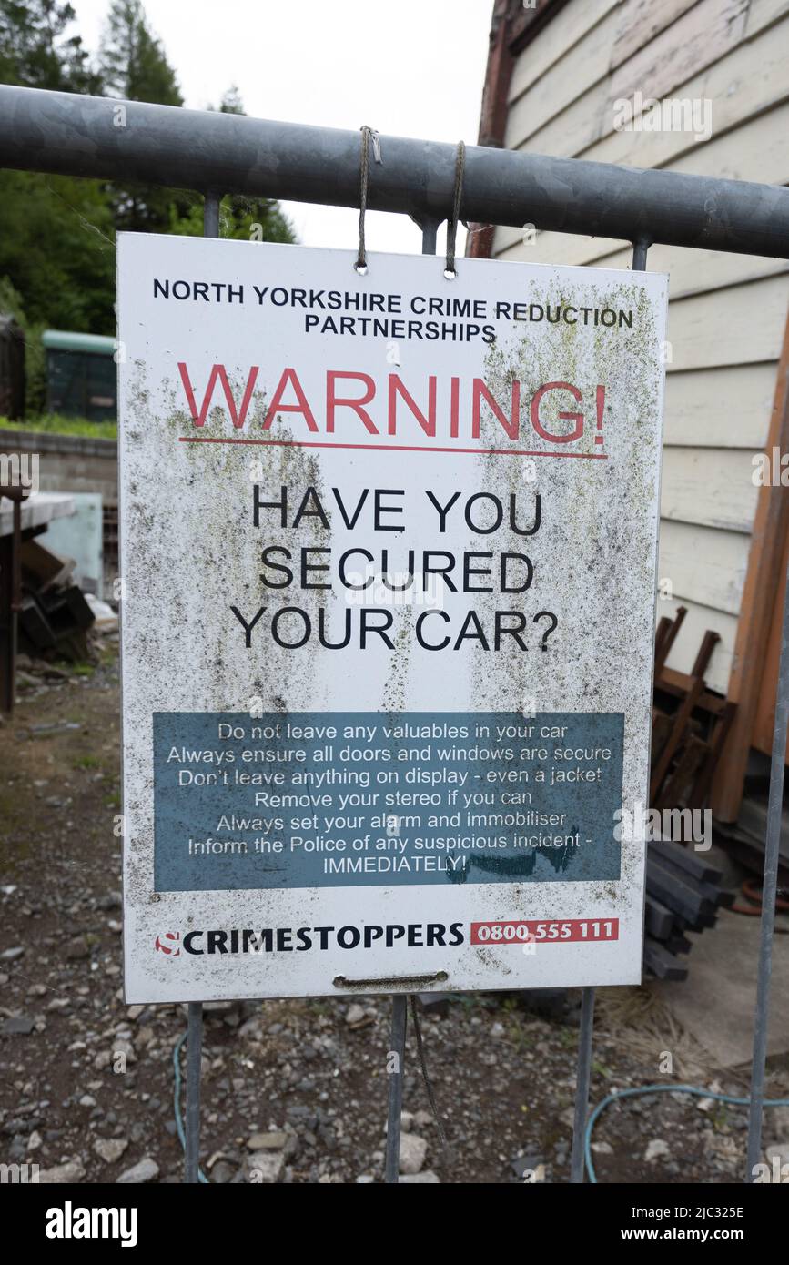Warning, have you secured your car sign from crimestoppers at Bolton Abbey railway station, Yorkshire, UK Stock Photo