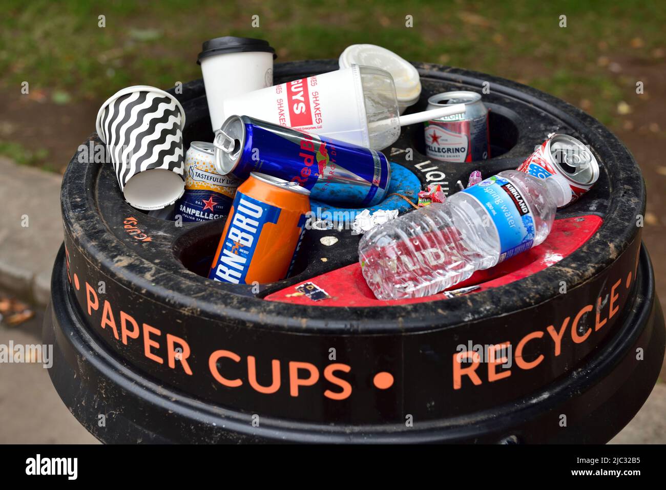 Recycling bin for paper cups filled with can, plastic bottles, along with paper cups Stock Photo