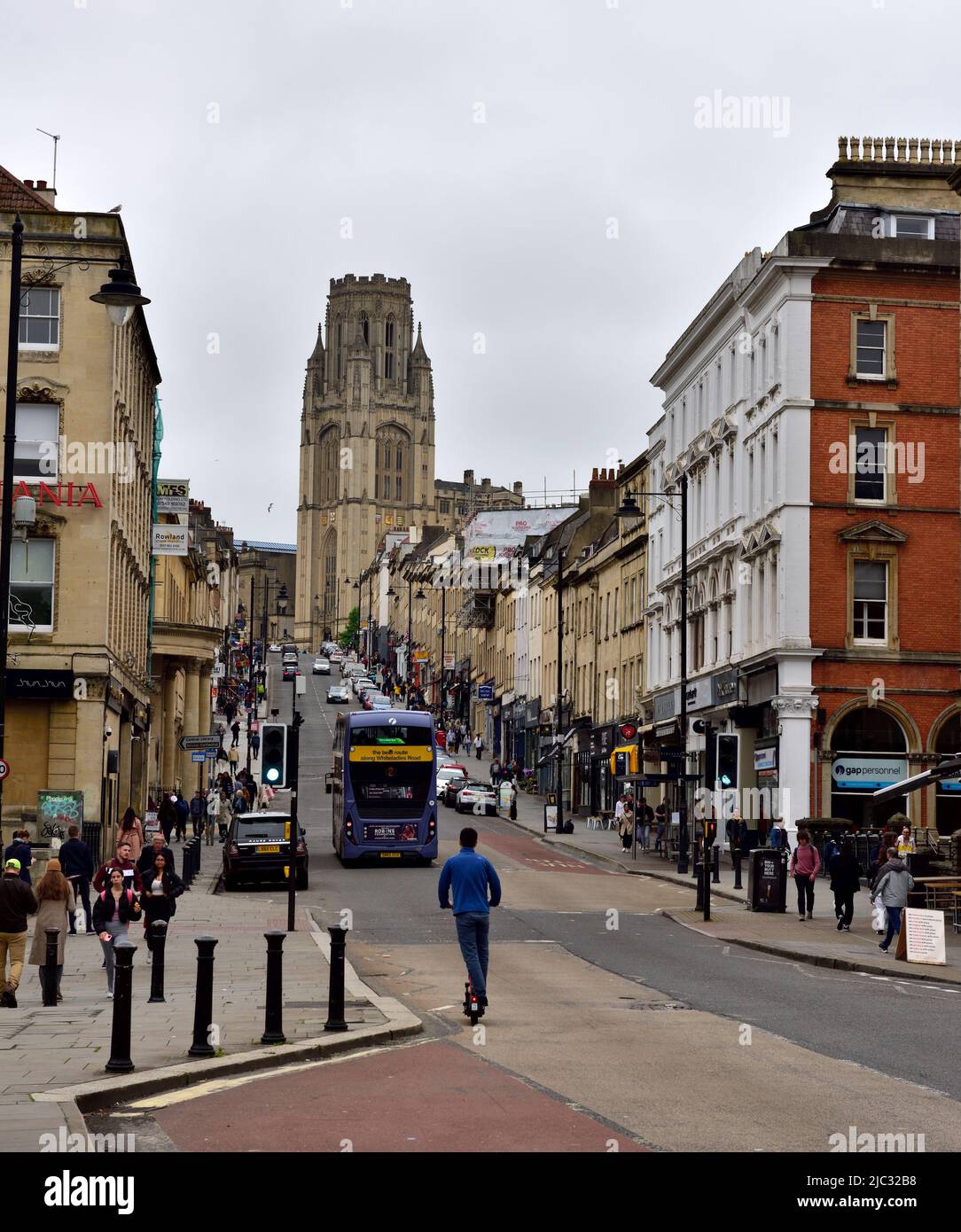 Looking up Park Street steep hill toward University Will Memorial building tower with bus and escooter, Bristol, UK Stock Photo