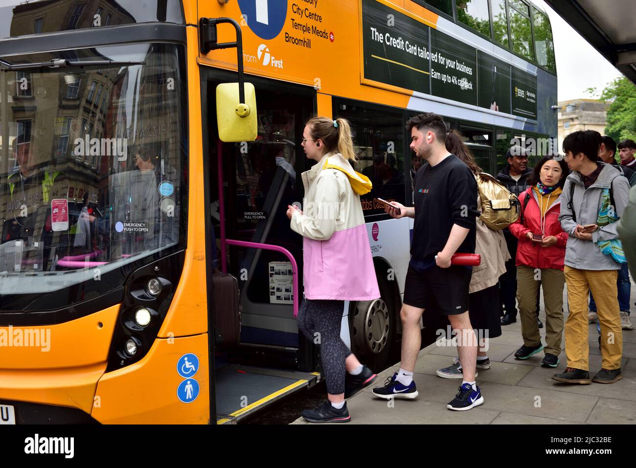 Passengers getting on double decker bus, Bristol bus stop using payment by mobile phone, UK Stock Photo