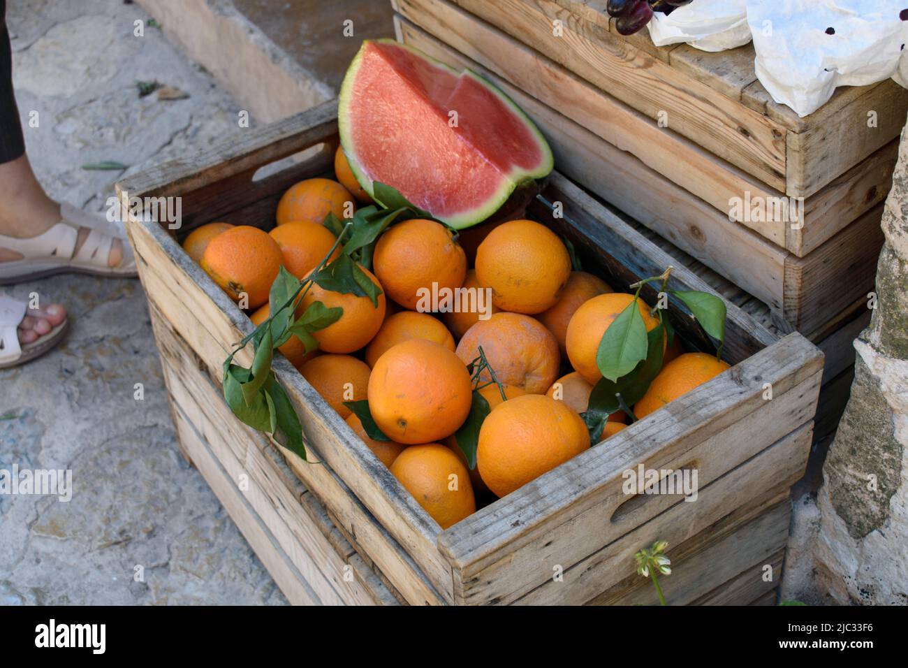Wooden box full of oranges and quarter of watermelon Stock Photo - Alamy