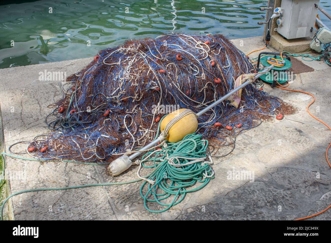 Tangled pile of fishing nets laying on dock Stock Photo Alamy