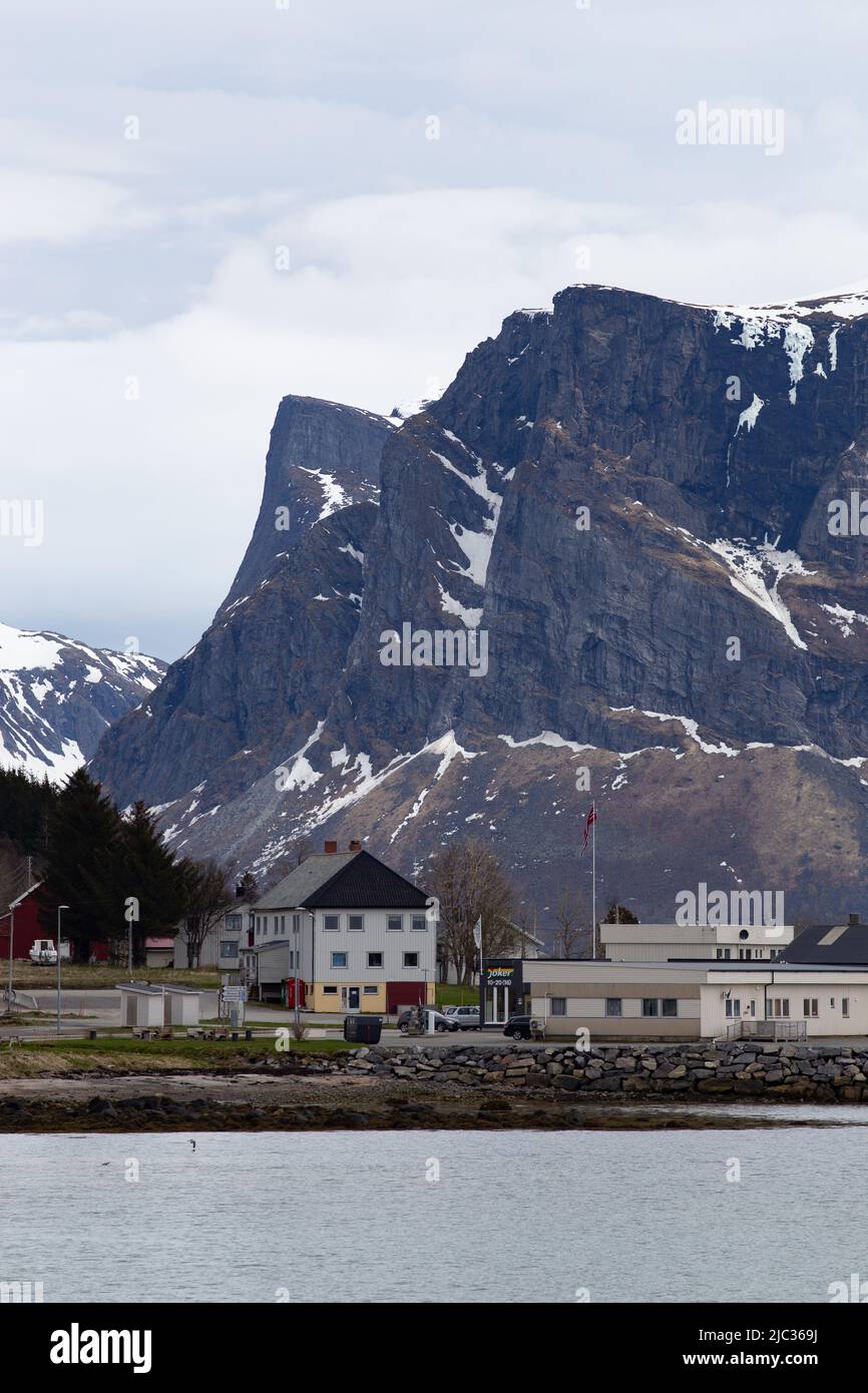 Groceries store in Skaland, Troms, with large mountains in the background, and the ocean in the foreground. Stock Photo