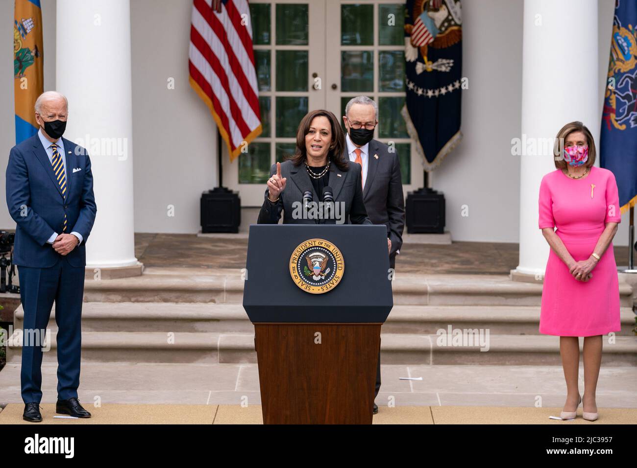 President Joe Biden, Senate Majority Leader Charles “Chuck” Schumer, D-N.Y., and House Speaker Nancy Pelosi, D-Calif., look on as Vice President Kamala Harris delivers remarks on the American Rescue Plan Friday, March 12, 2021, in the Rose Garden of the White House. Stock Photo