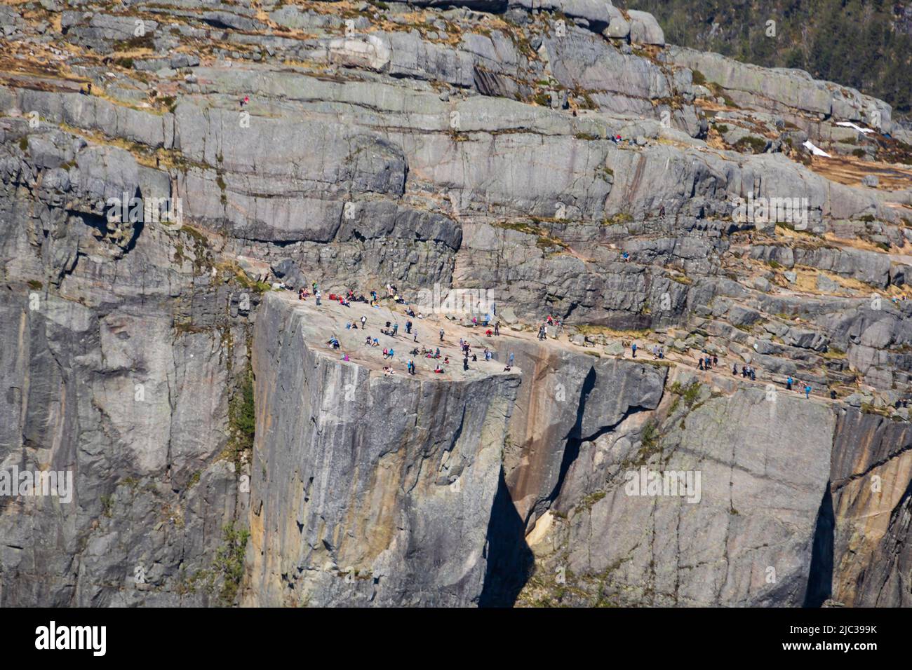 tourists and thrill seekers stand on Pulpit Rock, Preikestolen, high above the Lysefjord. Stavanger, Norway Stock Photo