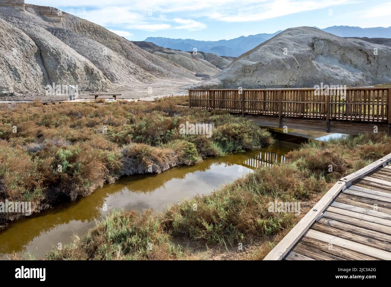 Salt Creek flows beneath a bridge in Death Valley, where visitors can learn about a rare pup fish on this interpretive boardwalk trail. Stock Photo