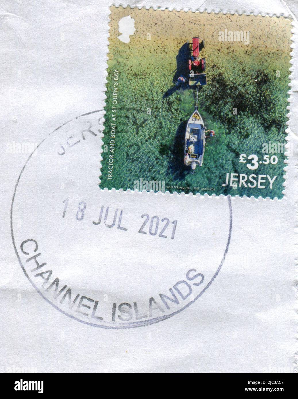 A Jersey postage stamp featuring a tractor and boat at St. Ouen's Bay, 18 July 2021. Stock Photo
