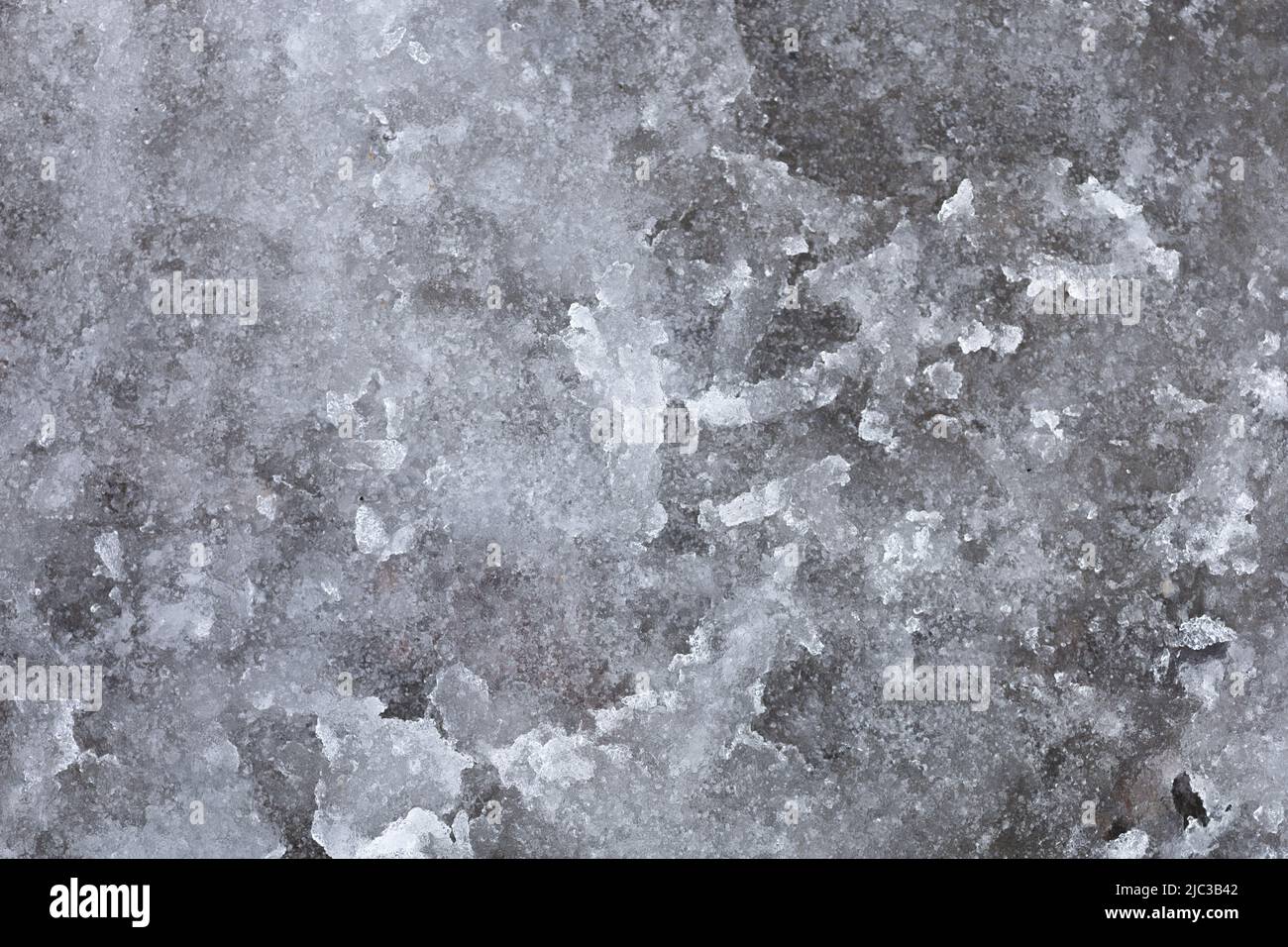 Abstract background with snow slush outside on street road caused by melting snow. Muddy snowy road. Winter is over and spring time comes when Stock Photo